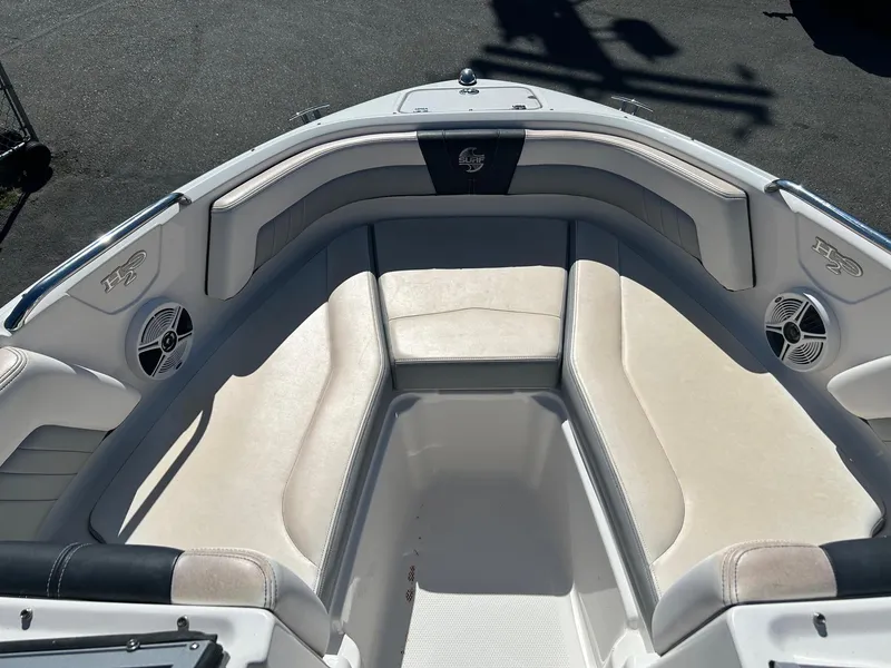 Slide: The Image of 2018 Chaparral 21 H2O Surf boat interior with cushioned seating and speakers. - 8