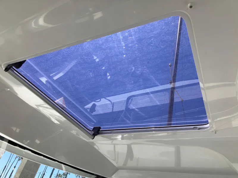 Slide: The Image of Sunroof of 2018 Jeanneau NC 695 boat, showcasing clear blue sky view. - 18