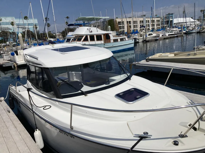 Slide: The Image of 2018 Jeanneau NC 695 boat docked at a marina with other vessels. - 3
