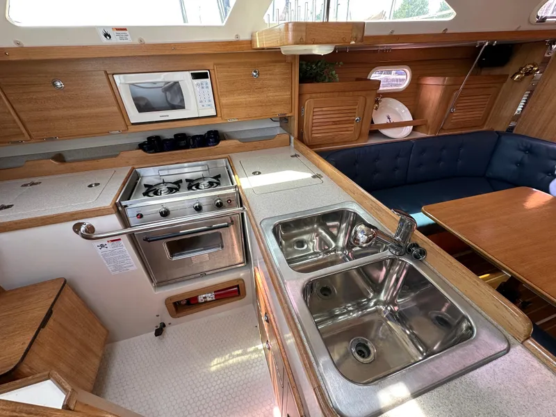 Slide: The Image of Catalina 36 MkII 2005 yacht interior with kitchen, stove, sink, and seating area. - 18