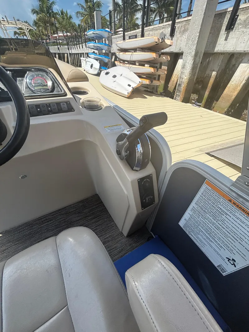 Slide: The Image of Interior of a 2021 Godfrey Sweetwater boat with control panel and docked kayaks. - 17