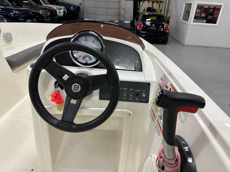 Slide: The Image of 2021 Bayliner Element E18 boat dashboard with steering wheel and control panel. - 10