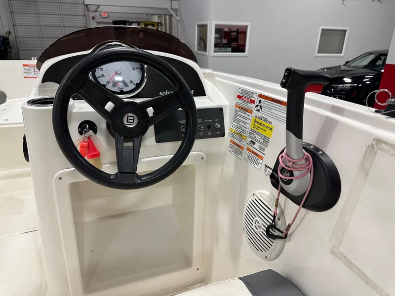 Slide: The Image of 2021 Bayliner Element E18 boat dashboard with steering wheel and control panel. - 11
