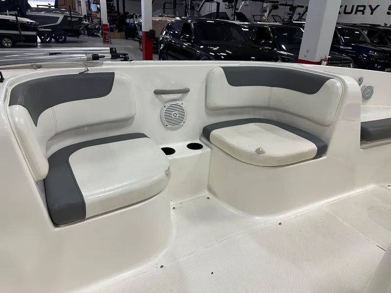 Slide: The Image of 2021 Bayliner Element E18 boat interior with gray and white seating in showroom. - 16