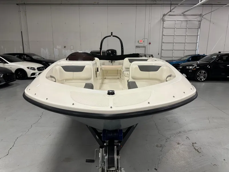 Slide: The Image of 2021 Bayliner Element E18 boat in showroom, surrounded by cars. - 3