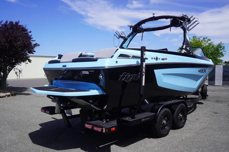 Slide: The Image of 2023 Tigé 23ZX boat on trailer, featuring sleek design and vibrant blue color. - 23