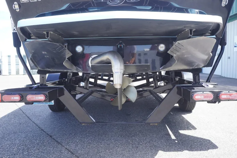 Slide: The Image of Rear view of 2023 Tigé 23ZX boat on trailer, showcasing propeller and exhaust system. - 26