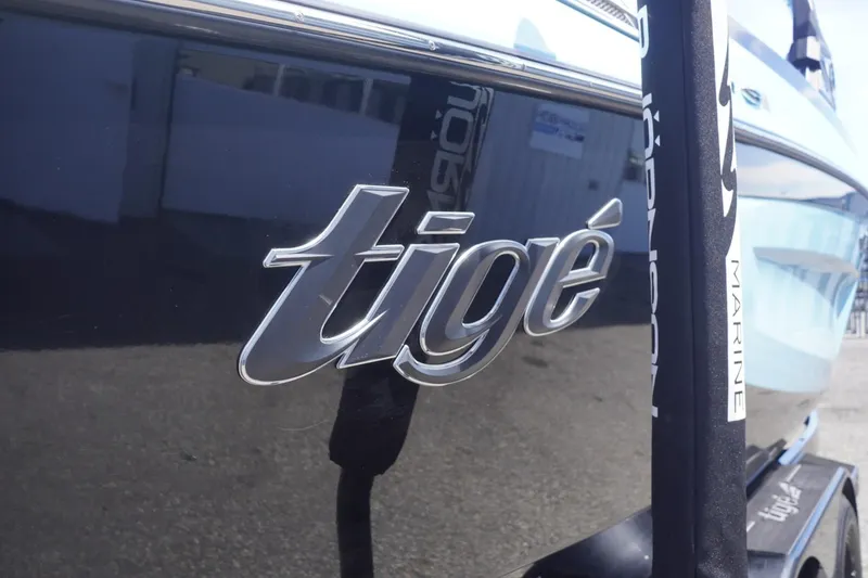 Slide: The Image of 2023 Tigé 23ZX boat logo on sleek black surface. - 4