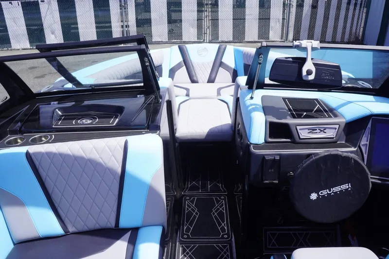 Slide: The Image of 2023 Tigé 23ZX boat interior with blue and gray seating, modern dashboard, and stylish design. - 42