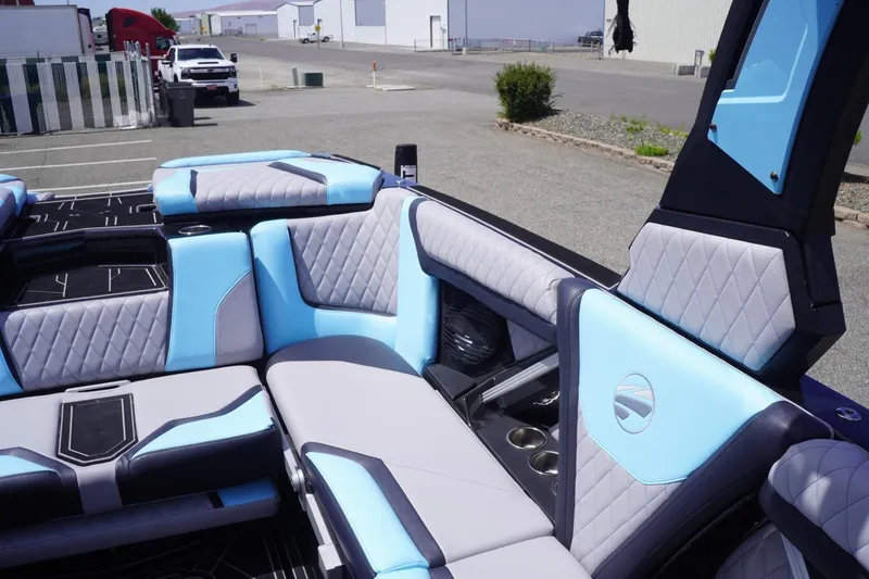 Slide: The Image of 2023 Tigé 23ZX boat interior with blue and gray quilted seating, cup holders, and modern design. - 44