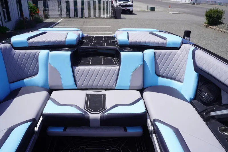 Slide: The Image of 2023 Tigé 23ZX boat interior with blue and gray seating, diamond stitching, and cup holders. - 45