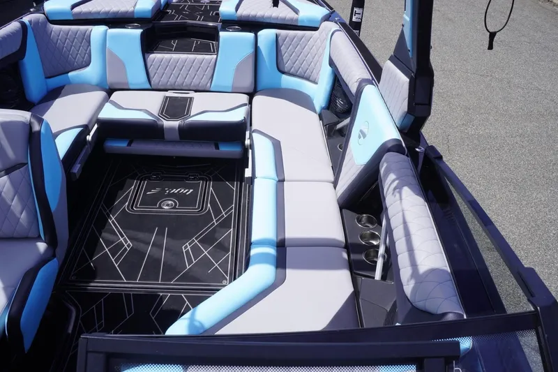 Slide: The Image of 2023 Tigé 23ZX boat interior with blue and gray seating, cup holders, and stylish flooring. - 47