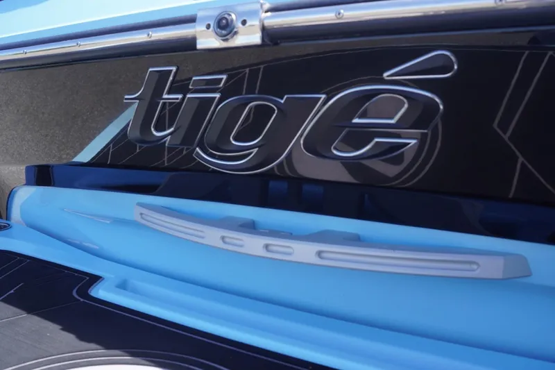 Slide: The Image of 2023 Tigé 23ZX boat logo on sleek black and blue exterior. - 6
