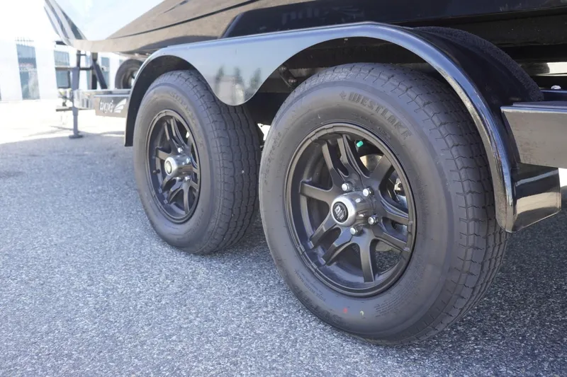 Slide: The Image of 2023 Tigé 23ZX trailer with black wheels on asphalt surface. - 9