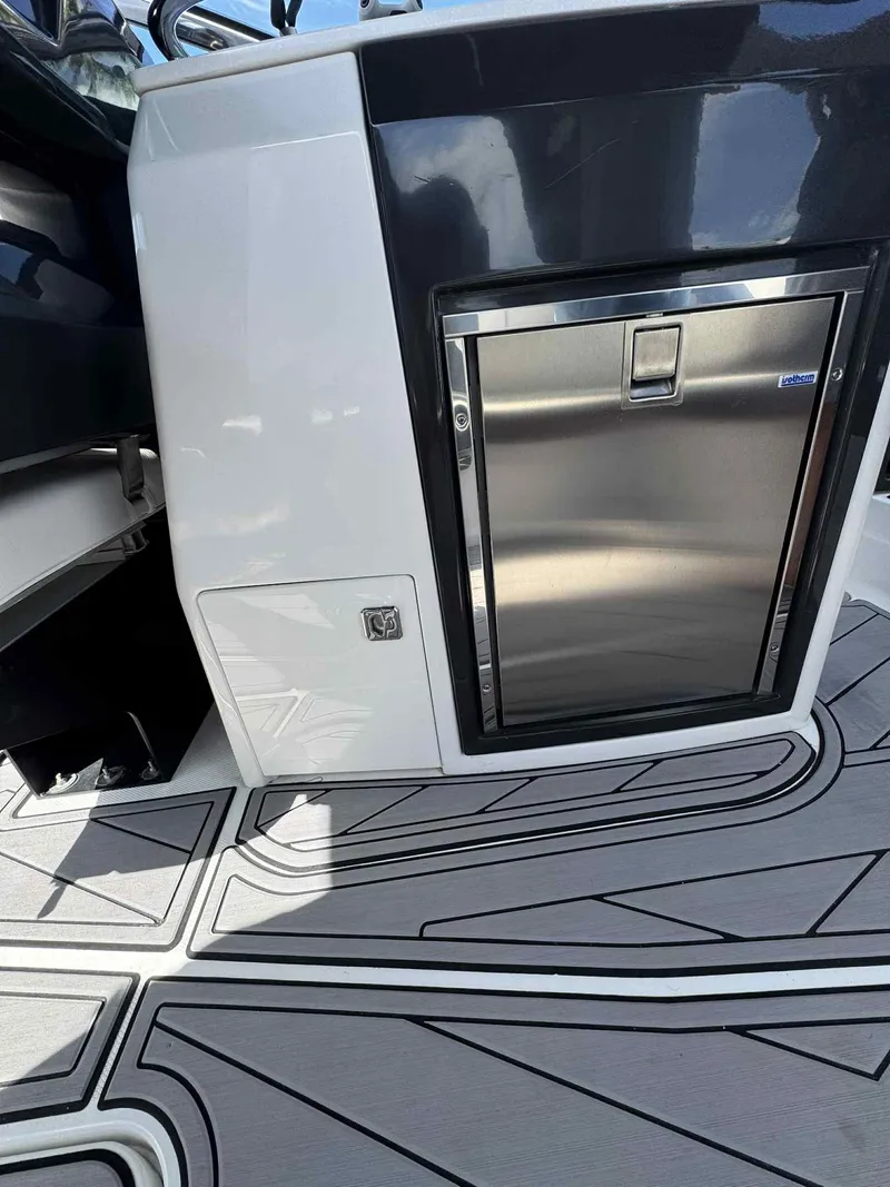 Slide: The Image of 2023 Monterey 275SS boat interior with sleek stainless steel fridge and modern flooring design. - 15