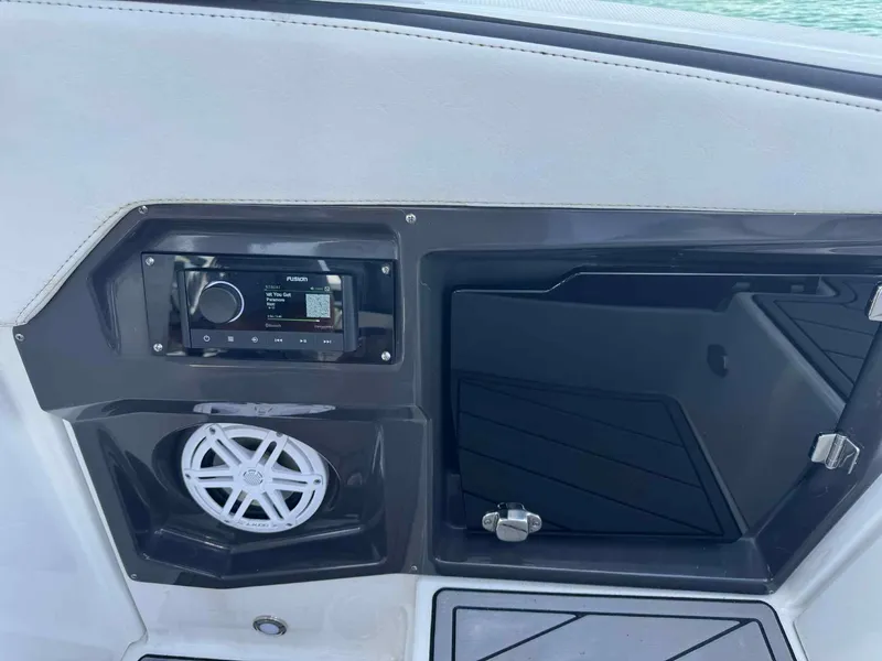 Slide: The Image of 2023 Monterey 275SS boat interior with audio system and storage compartment. - 18