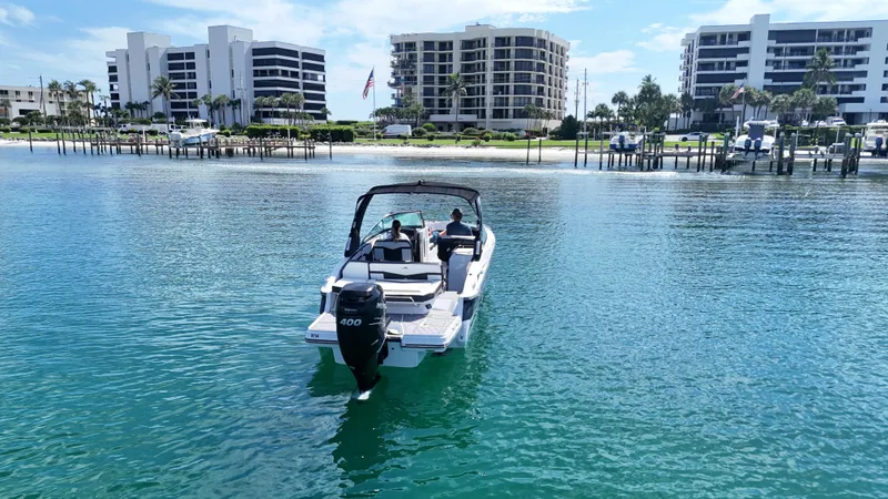 Slide: The Image of 2023 Monterey 275SS boat cruising near waterfront buildings and docks. - 2