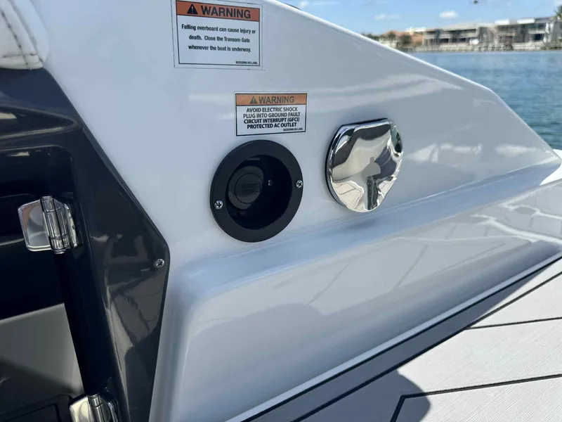 Slide: The Image of 2023 Monterey 275SS boat detail with warning labels and chrome fittings by the water. - 20