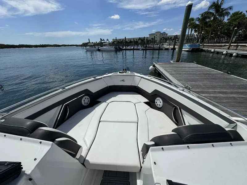 Slide: The Image of 2023 Monterey 275SS boat interior at dock, featuring spacious seating and scenic waterfront view. - 22