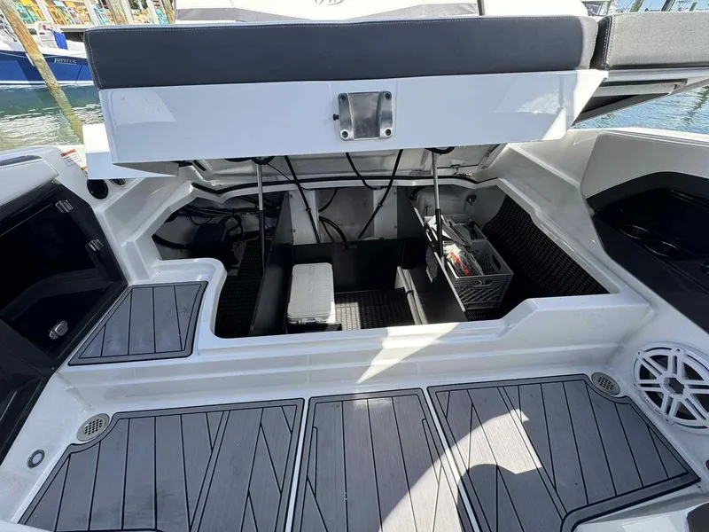 Slide: The Image of 2023 Monterey 275SS boat interior storage compartment with open hatch, showcasing organized space. - 24