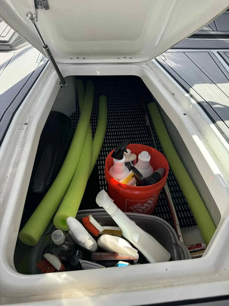 Slide: The Image of Storage compartment in 2023 Monterey 275SS boat with cleaning supplies and pool noodles. - 26