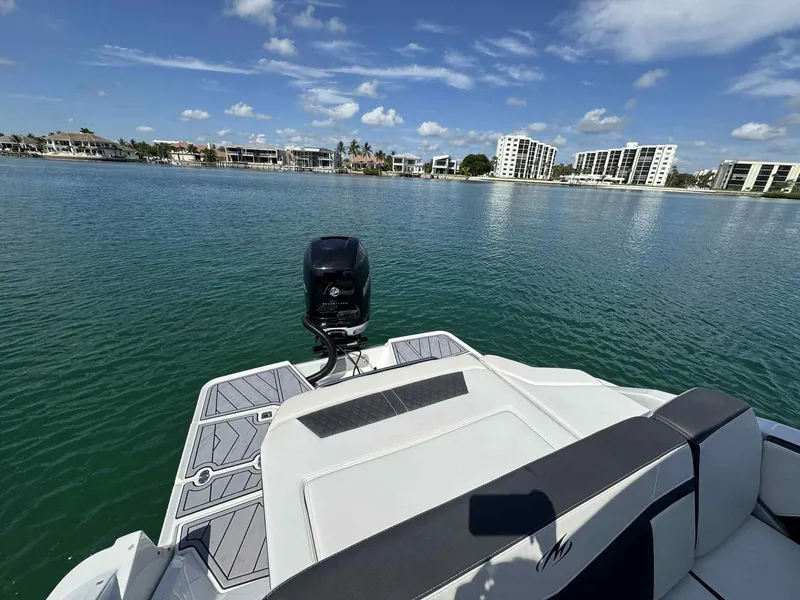 Slide: The Image of 2023 Monterey 275SS boat on calm water with modern buildings in the background. - 4