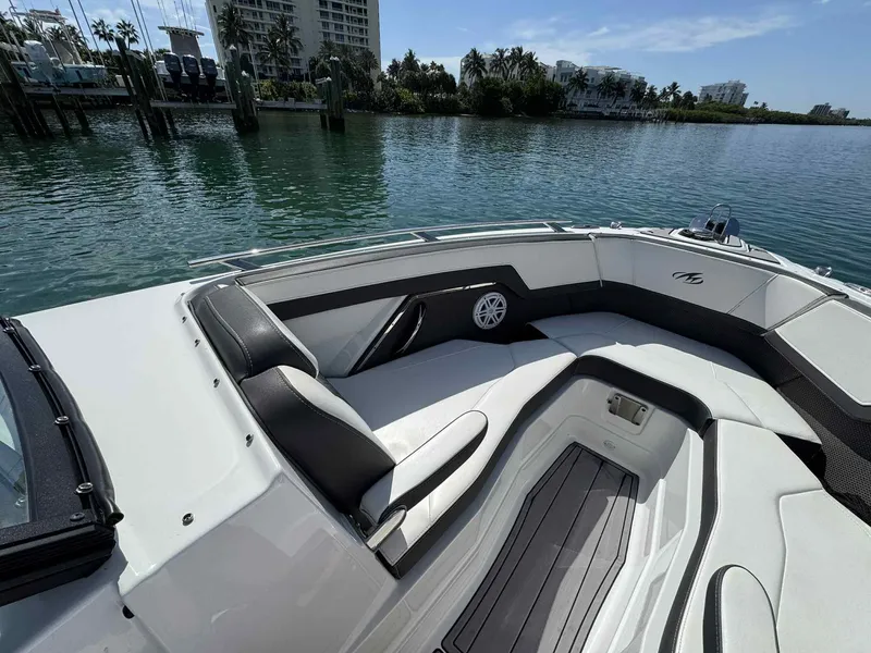 Slide: The Image of 2023 Monterey 275SS boat interior with luxurious seating, docked near waterfront buildings. - 8