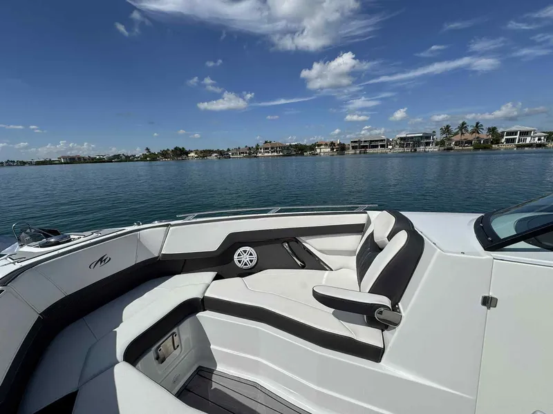 Slide: The Image of 2023 Monterey 275SS boat interior with luxurious seating, overlooking a serene waterfront view. - 9