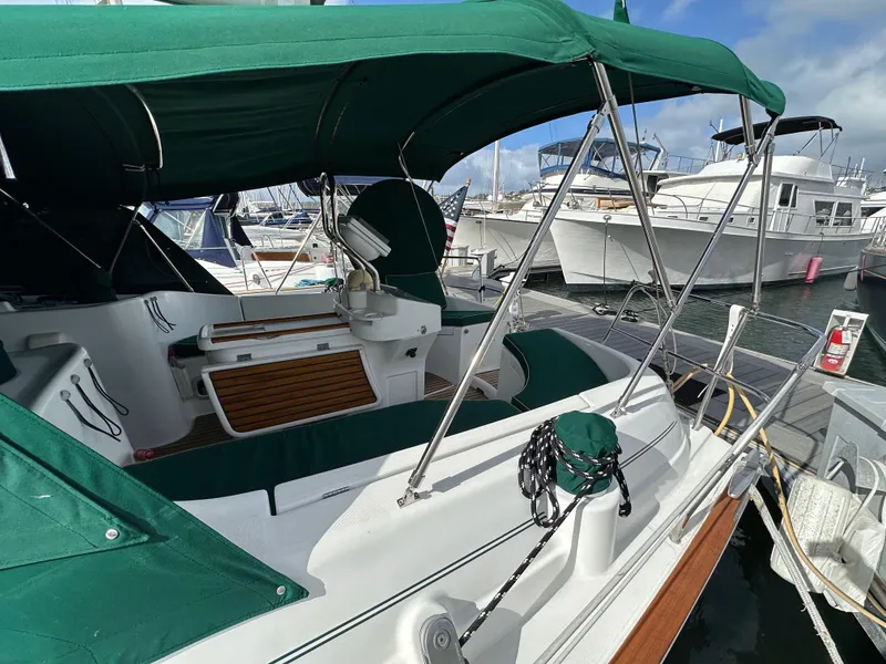Slide: The Image of 2002 Beneteau 411 sailboat with green canopy docked at marina. - 11