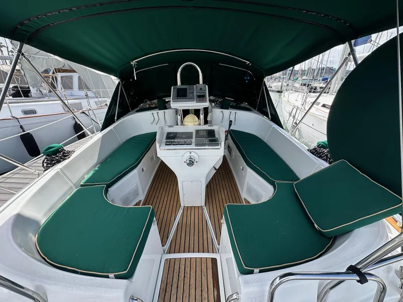 Slide: The Image of 2002 Beneteau 411 sailboat cockpit with green cushions and wood flooring. - 14