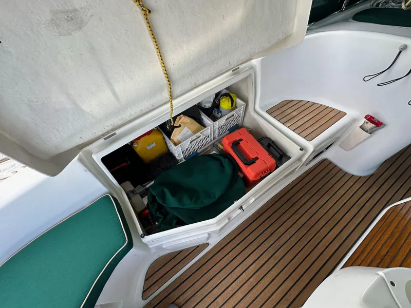 Slide: The Image of Storage compartment on a 2002 Beneteau 411 sailboat, featuring organized equipment and wooden flooring. - 19