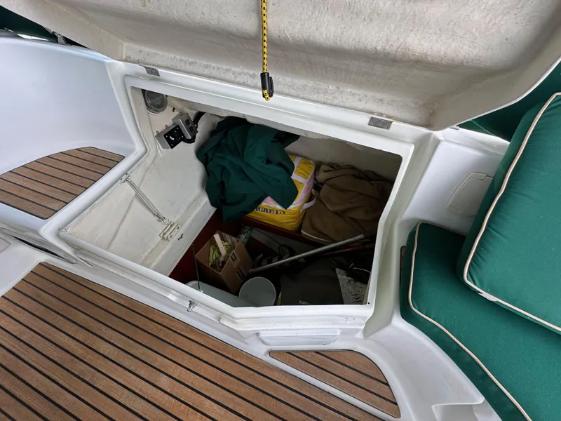 Slide: The Image of Open storage compartment on a 2002 Beneteau 411 sailboat, with various items inside. - 20