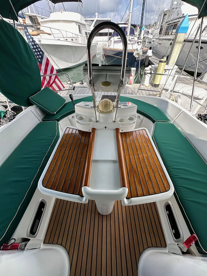 Slide: The Image of Beneteau 411 sailboat cockpit, 2002 model, featuring teak flooring and green cushioned seating. - 25