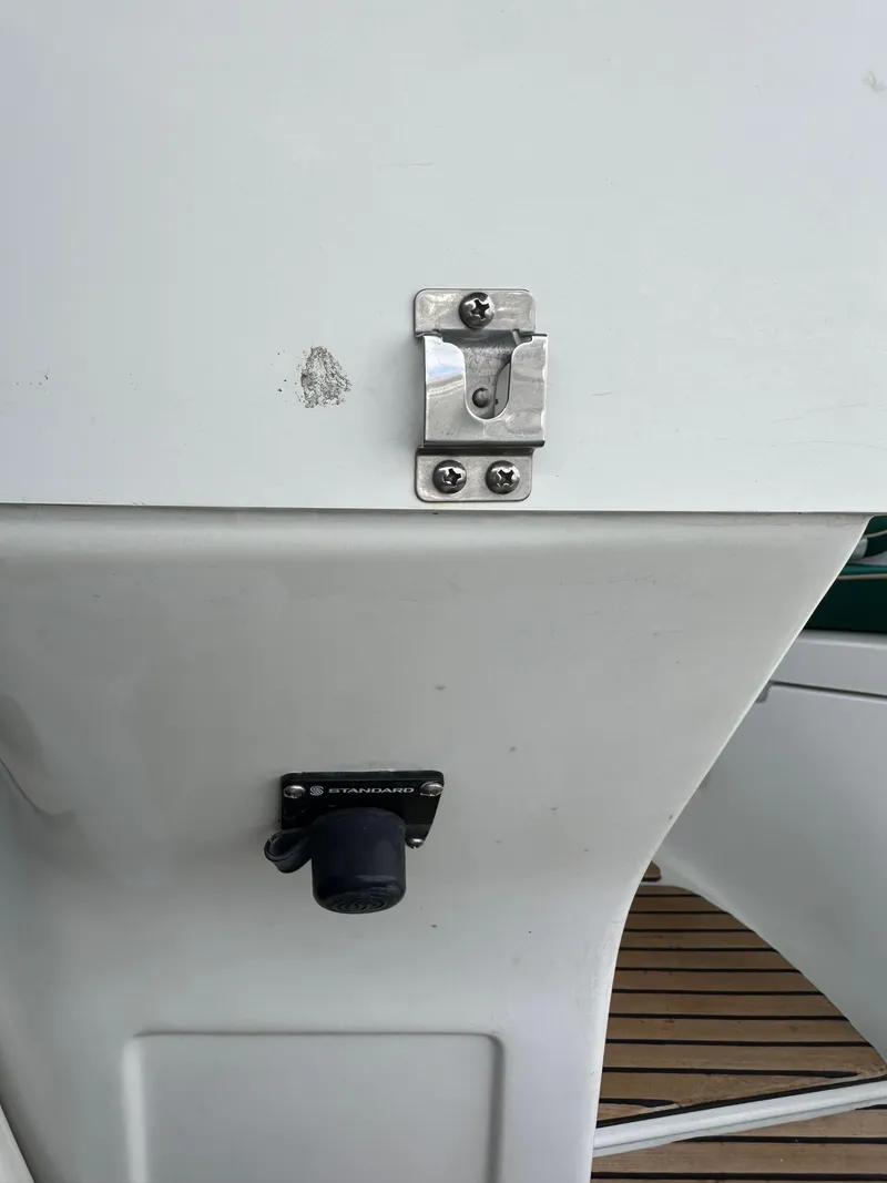 Slide: The Image of Close-up of a 2002 Beneteau 411 yacht's deck detail, featuring a latch and socket. - 26