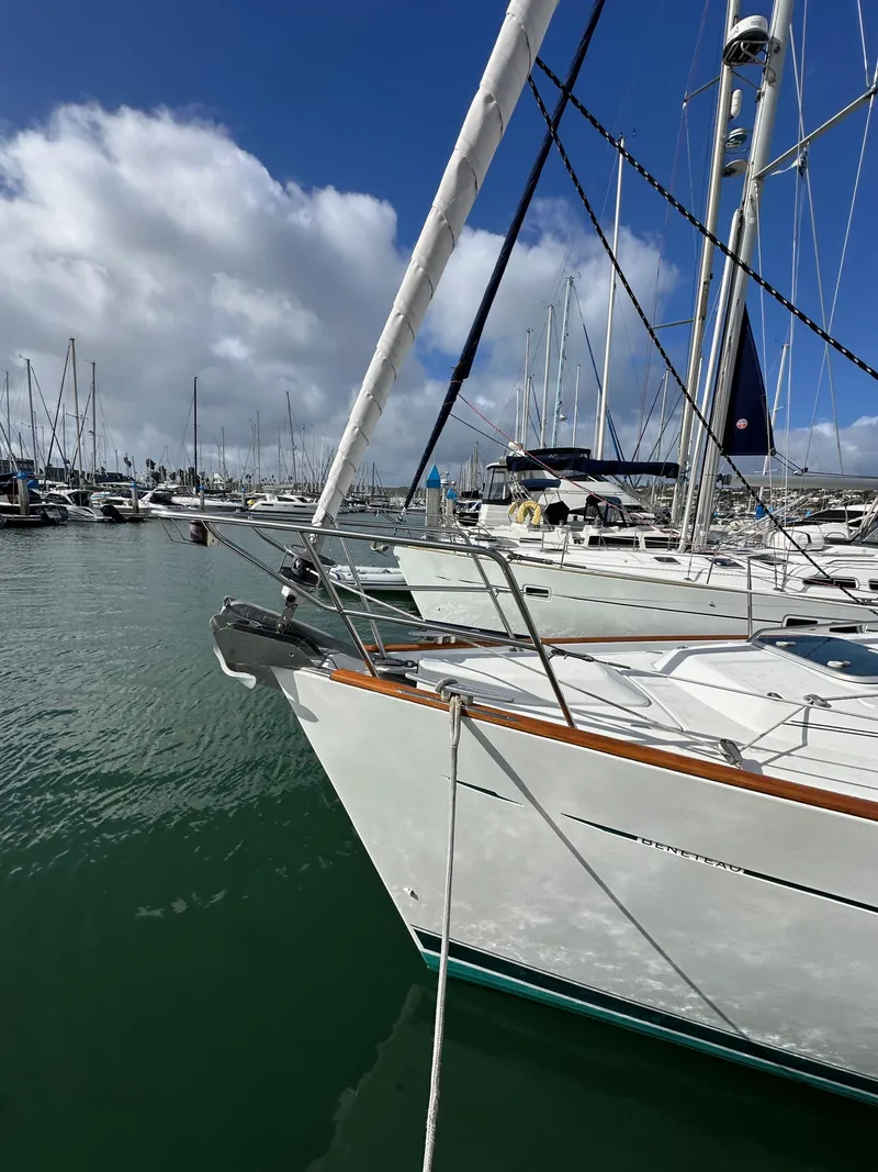 Slide: The Image of 2002 Beneteau 411 sailboat docked in a marina under a partly cloudy sky. - 3