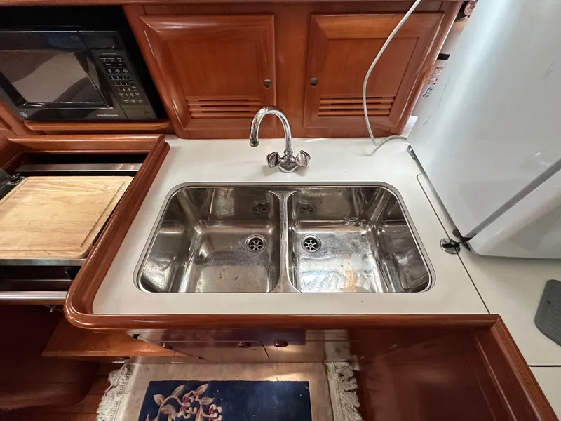 Slide: The Image of Double sink in 2002 Beneteau 411 yacht kitchen with wooden cabinetry. - 35