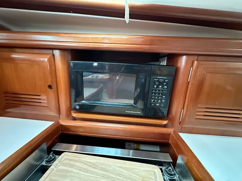 Slide: The Image of Beneteau 411 (2002) yacht kitchen with microwave and wooden cabinetry. - 38