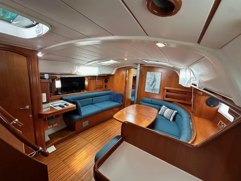 Slide: The Image of Interior of 2002 Beneteau 411 yacht with wooden finish and blue seating. - 39