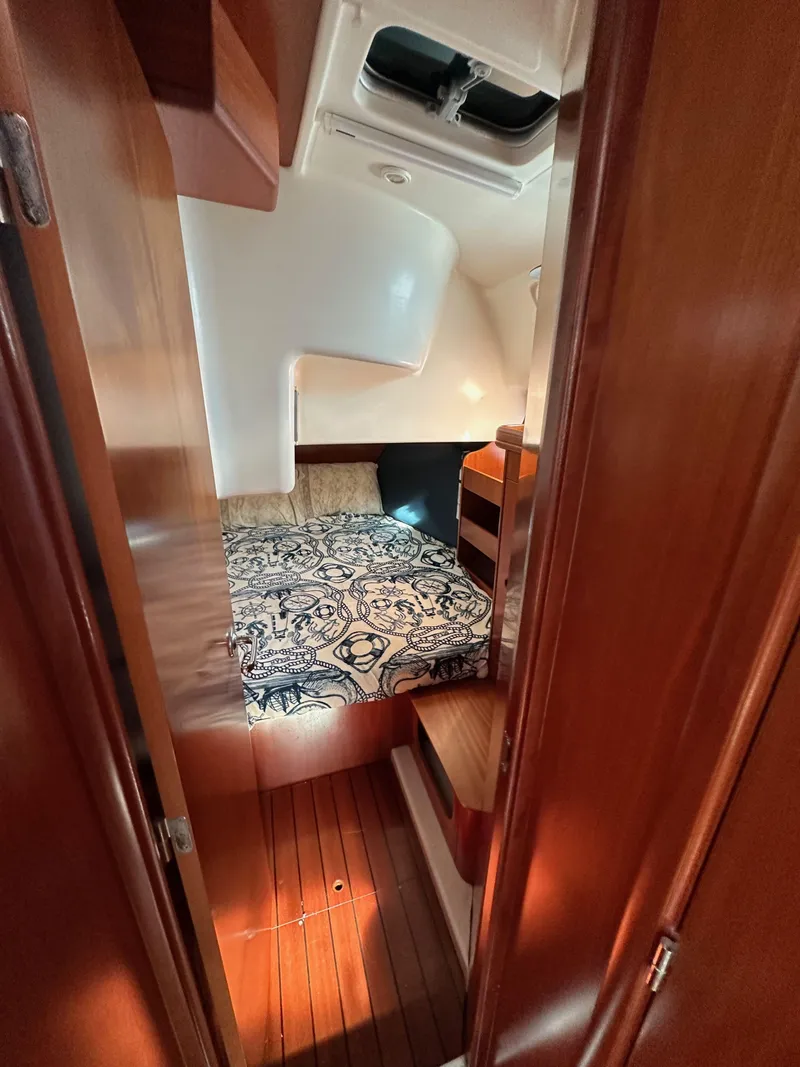 Slide: The Image of Cozy cabin interior of 2002 Beneteau 411 sailboat with patterned bedding and wooden finishes. - 42