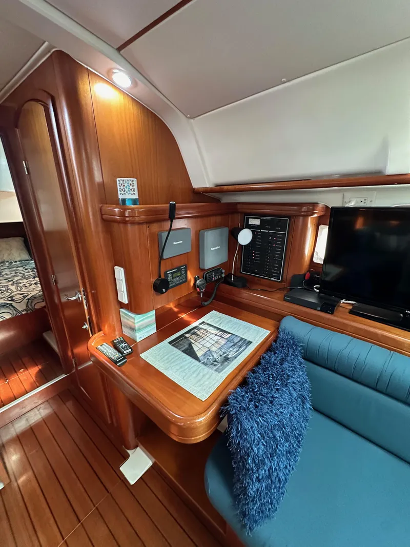 Slide: The Image of Interior of 2002 Beneteau 411 yacht with navigation station and cozy seating area. - 47