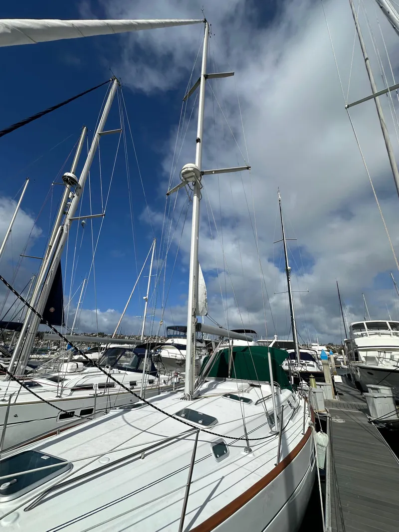Slide: The Image of 2002 Beneteau 411 sailboat docked at marina under blue sky. - 5