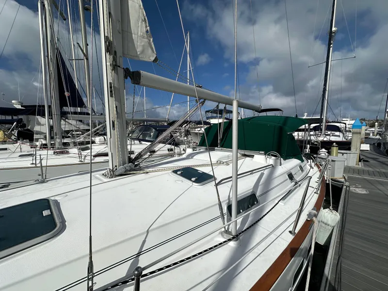 Slide: The Image of 2002 Beneteau 411 sailboat docked at marina under a partly cloudy sky. - 8