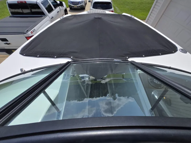 Slide: The Image of 2021 Monterey M-65 boat with black cover, parked near trucks. - 14