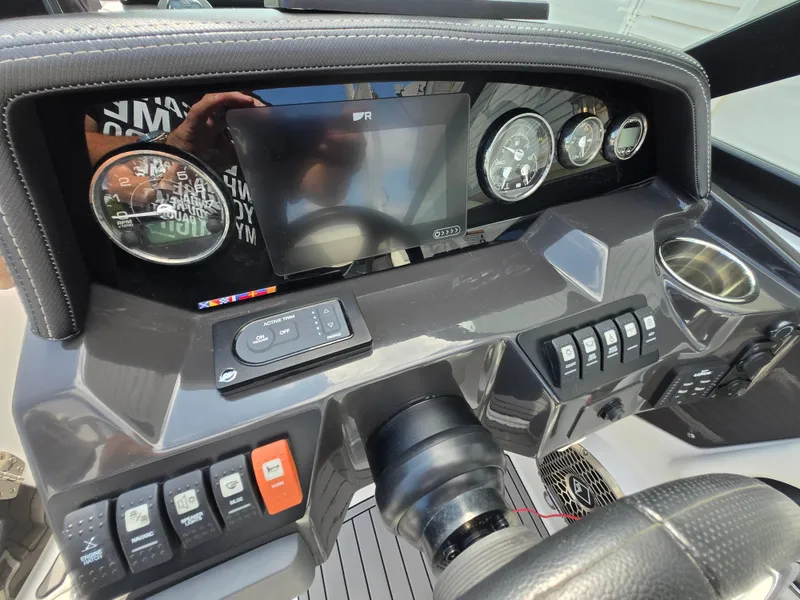 Slide: The Image of Dashboard of a 2021 Monterey M-65 boat with gauges, controls, and a display screen. - 17