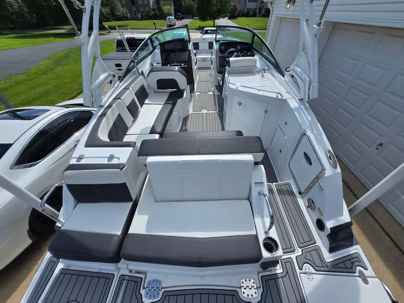 Slide: The Image of 2021 Monterey M-65 boat with sleek seating and modern design, parked in a driveway. - 2