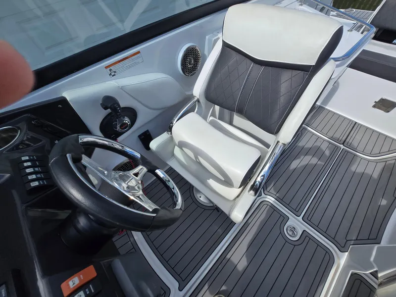 Slide: The Image of Captain's seat and steering wheel of 2021 Monterey M-65 boat, featuring sleek design and controls. - 22