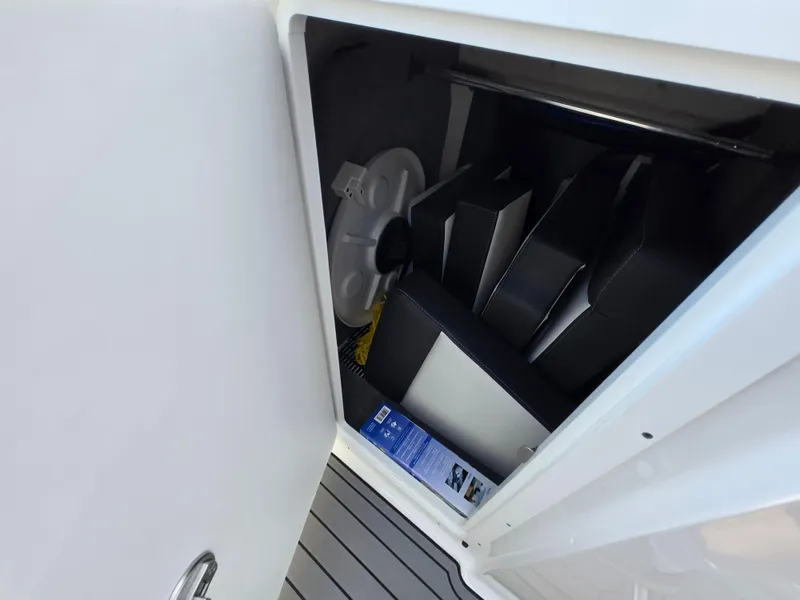 Slide: The Image of Storage compartment in a 2021 Monterey M-65 boat, containing cushions and a life preserver. - 26