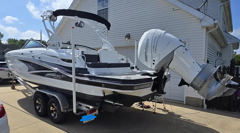Slide: The Image of 2021 Monterey M-65 boat on trailer, parked beside a house, featuring a Mercury outboard motor. - 3