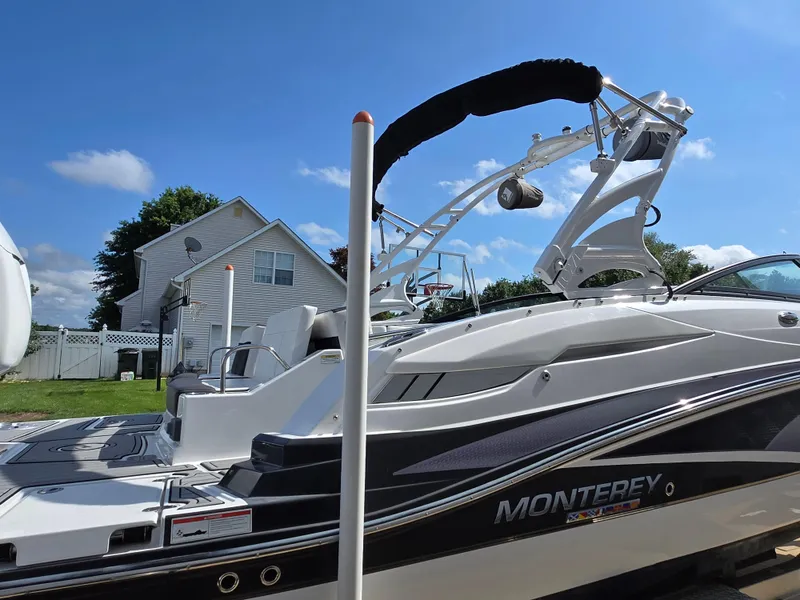 Slide: The Image of 2021 Monterey M-65 boat with sleek design, parked outdoors under clear blue sky. - 31