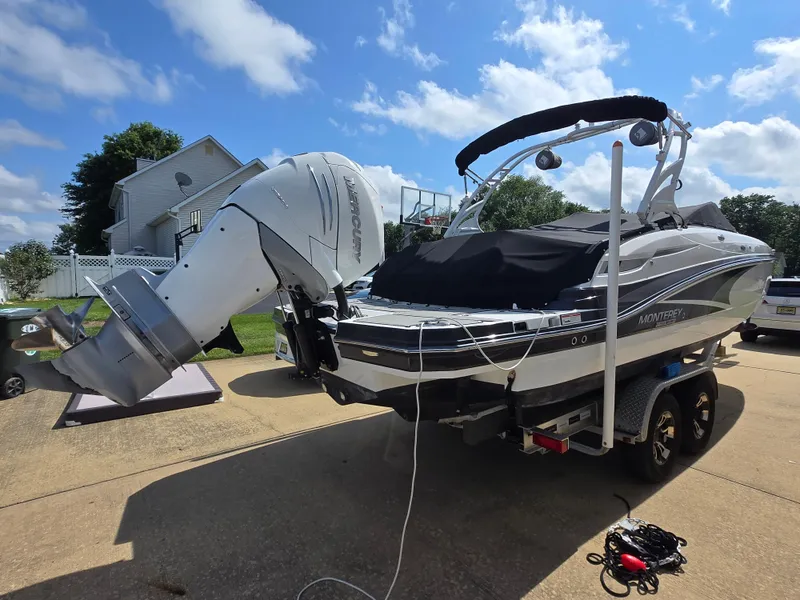 Slide: The Image of 2021 Monterey M-65 boat with Mercury engine on trailer, parked in driveway. - 6